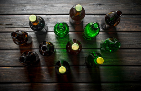 Glass bottled beer. On black wooden backgroundの写真素材