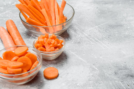 Slices of carrots in a glass bowl. On rustic backgroundの写真素材