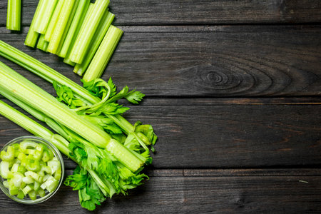 Fresh juicy celery in a bowl. On wooden background