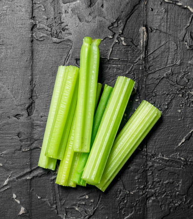 Pieces of fresh celery. On black rustic backgroundの写真素材