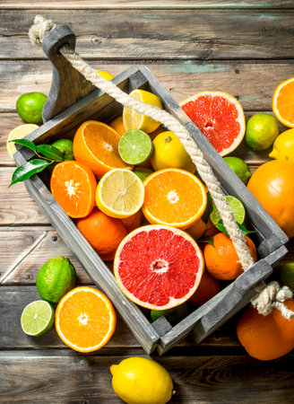 Pieces of fresh citrus in the box. On wooden backgroundの写真素材