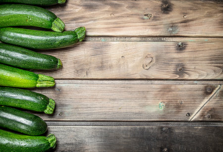 Fresh green zucchini. On wooden backgroundの写真素材