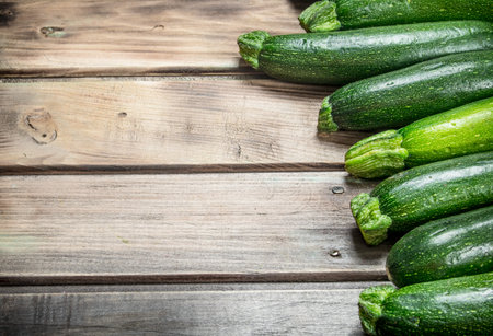 Fresh green zucchini. On wooden backgroundの写真素材