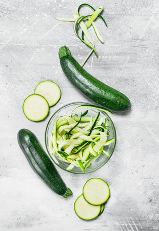 Pieces of zucchini in a glass bowl. On rustic backgroundの写真素材