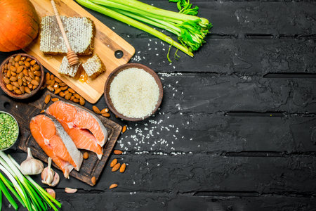 Health food. Salmon steaks with honey and organic food. On black rustic background.の写真素材
