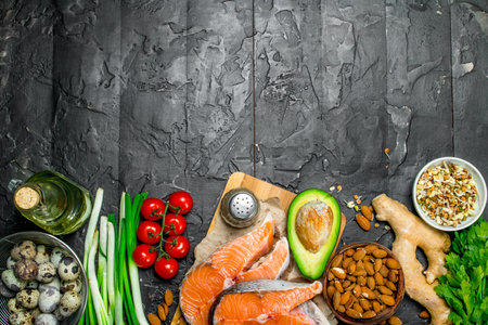 Health food. Salmon with vegetables and herbs. On a black rustic background.の写真素材