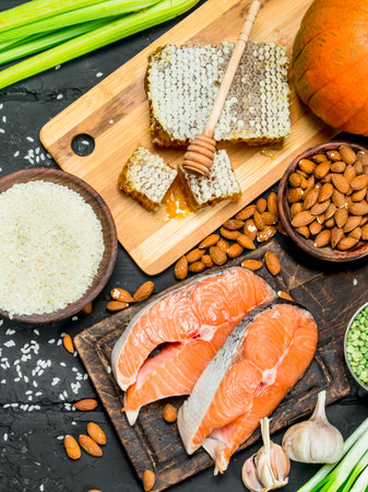 Health food. Salmon steaks with honey and organic food. On black rustic background.の写真素材