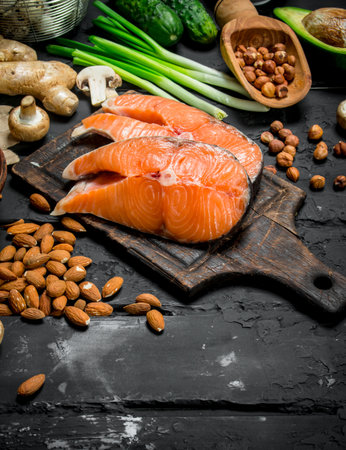 Health food. Raw salmon fish with organic food. On black rustic background.の写真素材