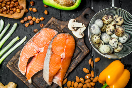 Health food. Raw salmon fish with organic food. On black rustic background.の写真素材
