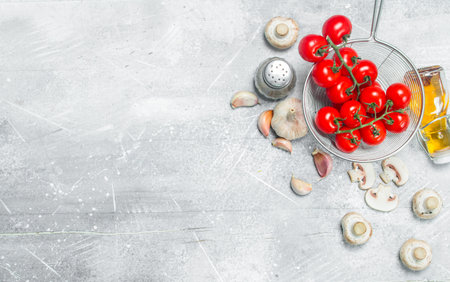 organic food. Fresh tomatoes with mushrooms and spices. On a rustic background.の写真素材