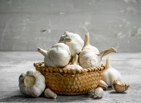 Garlic in basket. On rustic backgroundの写真素材
