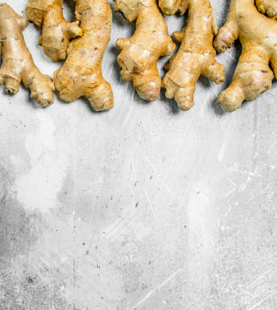 Fragrant fresh ginger. On white rustic backgroundの写真素材