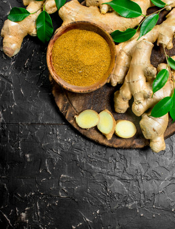 Ground and fresh sliced ginger on a cutting Board. On rustic background