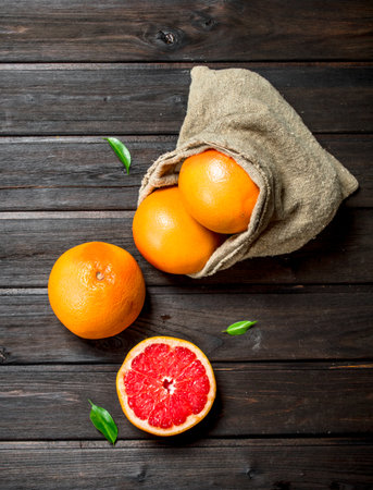 Grapefruits in an sack. On black wooden backgroundの写真素材