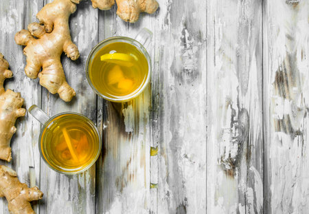 Ginger tea and fresh ginger. On wooden backgroundの写真素材