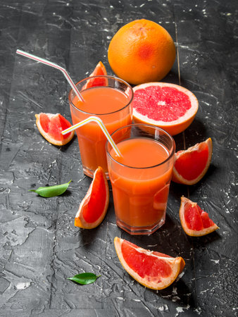 Grapefruit juice in a glass. On black rustic backgroundの写真素材