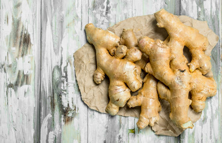 fresh ginger on paper. On wooden backgroundの写真素材