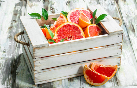 Fresh grapefruit in wooden box. On white wooden backgroundの写真素材