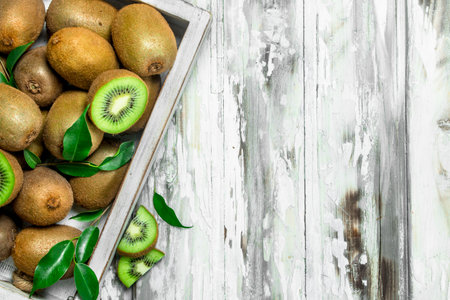 Ripe kiwi on a tray. On wooden backgroundの写真素材