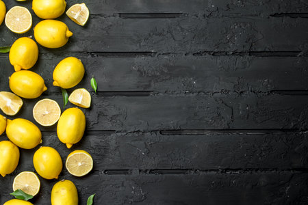 Ripe juicy lemons. On black rustic backgroundの写真素材