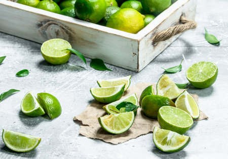 Fresh lime on tray and lime slices on paper. On rustic backgroundの写真素材