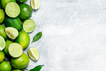Fresh juicy lime with leaves. On white rustic background