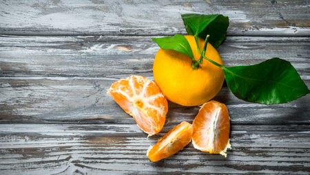 Fresh juicy tangerines with leaves. On wooden backgroundの写真素材