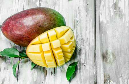 Ripe juicy mango. On wooden backgroundの写真素材