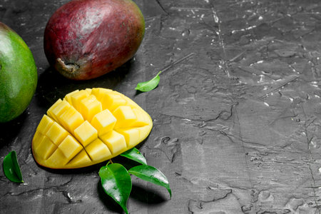 Fragrant ripe mango. On black rustic backgroundの写真素材