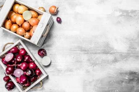 Whole and half onions in the box and on the tray. On white rustic backgroundの写真素材