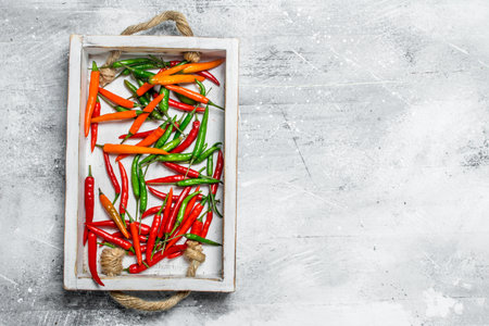 Spicy flavorful pepper on the tray. On rustic backgroundの写真素材