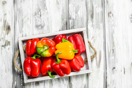 Ripe sweet pepper on tray. On white wooden backgroundの写真素材