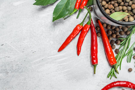 Pepper peas in a cup with red hot pepper, Bay leaf and rosemary. On rustic background