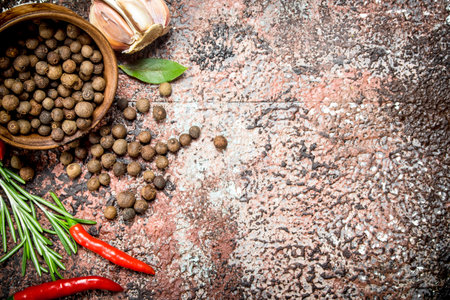 Fragrant pepper peas in a bowl with hot pepper, garlic and rosemary. On rustic backgroundの写真素材