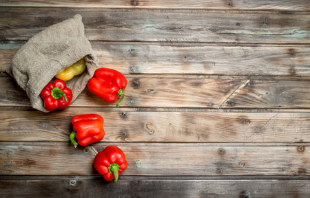 Fresh sweet pepper in the sack. On wooden backgroundの写真素材