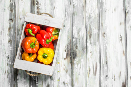 Fresh fragrant pepper in the box. On white wooden backgroundの写真素材