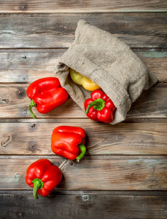 Fresh sweet pepper in the sack. On wooden backgroundの写真素材