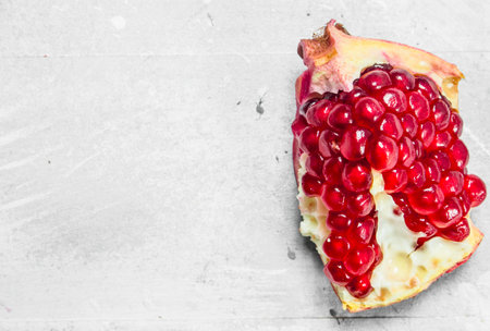 Piece of ripe pomegranate. On white rustic backgroundの写真素材