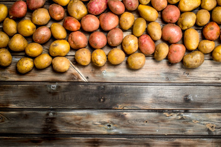 yellow and red potatoes. On wooden backgroundの写真素材