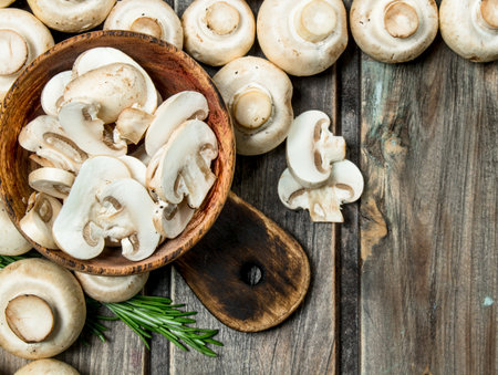 Pieces of fragrant mushrooms in bowl on cutting Board. On wooden backgroundの写真素材