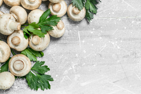 Fresh mushrooms with greens. On white rustic backgroundの写真素材