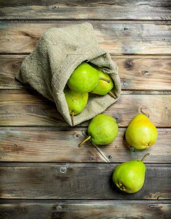 Fresh pear in the sack. On wooden backgroundの写真素材