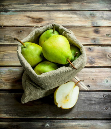 Fresh pear in the sack. On wooden backgroundの写真素材