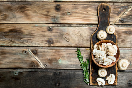 Pieces of fragrant mushrooms in bowl on cutting Board. On wooden backgroundの写真素材
