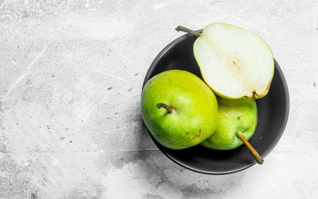 Fresh pear in the bowl. On rustic backgroundの写真素材