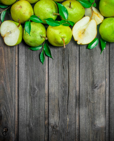 Fragrant ripe pears with foliage. On wooden backgroundの写真素材