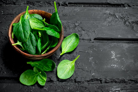 Spinach is in the bowl. On black rustic backgroundの写真素材