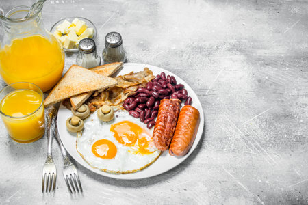 English breakfast. A variety of snacks with orange juice. On a rustic background.の写真素材