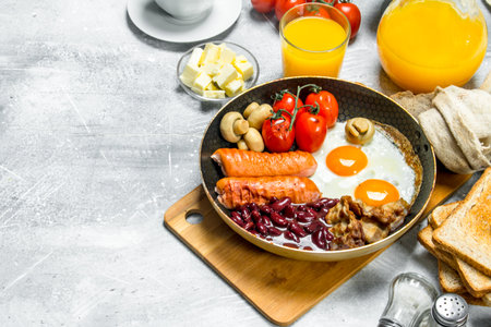 English breakfast. A variety of snacks with orange juice. On a rustic background.の写真素材