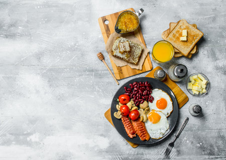 English breakfast. A variety of snacks with orange juice. On a rustic background.の写真素材